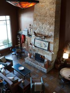 a living room with a stone fireplace and a couch at Wildwood Lodge in Pewaukee