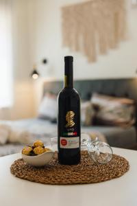 una botella de vino sentada en una mesa con un tazón de cacahuetes en אבן על הנחל, en Merhav Am