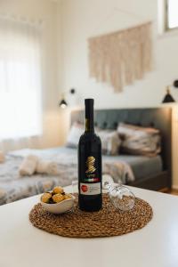una botella de vino y un tazón de comida en una mesa en אבן על הנחל en Merhav Am