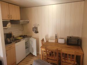 una piccola cucina con tavolo in legno e forno a microonde di Haus Andrea a Lichtenberg