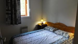 a bedroom with a bed and a lamp on a table at Résidence Soleil D'aure - Appartement 4 personnes à deux pas du centre MAE-3564 in Cadeilhan-Trachère