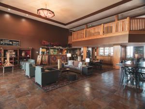 a living room with couches and tables and a staircase at Wildwood Lodge in Pewaukee