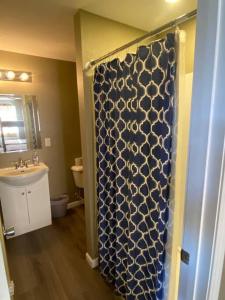 uma casa de banho com um chuveiro com uma cortina azul e branca em Villa #3 Sleep 6-Bachelor/Bachelorette Parties! em Lake Ozark