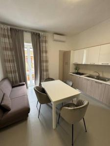 a living room with a table and chairs and a kitchen at CASA LUISA - Comfortable APT in San Vitaliano  +14 photos