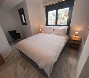 a bedroom with a large white bed with a window at Casa Bianca in Kavala