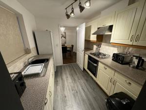 een keuken met houten vloeren en witte apparatuur bij Modern 3 Bedroom House Close to Liverpool Centre in West Derby