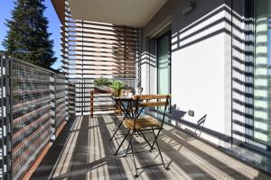 a balcony with a wooden table and chairs at CaseOspitali - Casa Marina grande bilocale con terrazzo perfetto x2 in Cernusco sul Naviglio