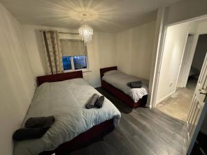 a bedroom with two beds and a chandelier at Modern 3 Bedroom House Close to Liverpool Centre in West Derby
