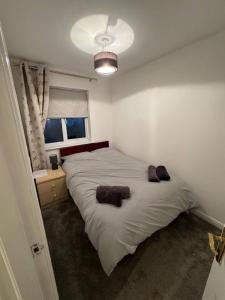 a bedroom with a large bed with two towels on it at Modern 3 Bedroom House Close to Liverpool Centre in West Derby