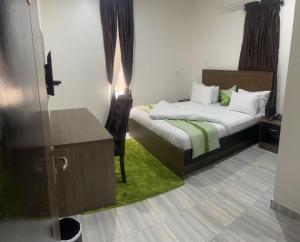 a bedroom with a bed and a dresser with a window at Elimus Apartments & Suites 