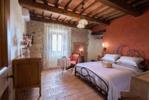 特拉西梅诺湖畔帕西尼亚诺Di Colle in Colle - Agriturismo的房间里有一张床和一把椅子的卧室