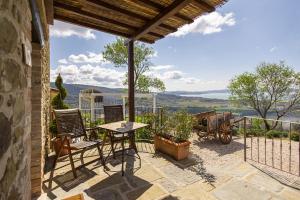 a patio with a table and chairs on a balcony at Di Colle in Colle - Agriturismo in Passignano sul Trasimeno