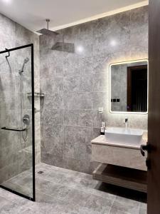 y baño con lavabo y ducha. en Khozama Living 2 - Alnahda en Yeda
