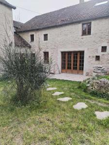 una casa de piedra con un patio con escalones en chambres d'hôtes rue Pasteur en Is-sur-Tille