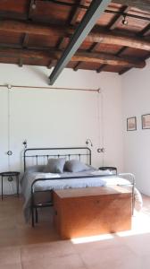 una camera con letto in una stanza con soffitti in legno di La Casetta del Pàstine, Il Borgo Diffuso di San Michele a San Michele in Teverina