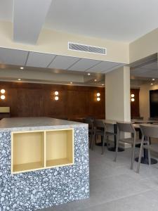 a lobby with a counter and tables and chairs at Hotel des Victoires - Restaurant in Cannes