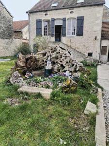 una casa con un jardín de rocas delante de ella en chambres d'hôtes rue Pasteur en Is-sur-Tille