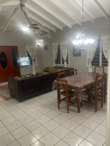 uma sala de estar com uma mesa e um sofá em Mountain view Apartment em Basseterre