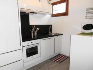 une cuisine avec des armoires blanches et un évier dans l'établissement Résidence Le Palos - Appartement 6 personnes à deux pas du centre MAE-6224, à Cadeilhan-Trachère