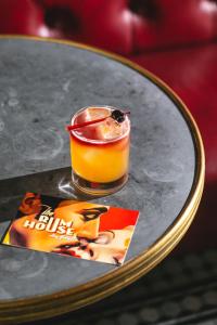a drink sitting on top of a table with a magazine at Hotel Edison Times Square in New York