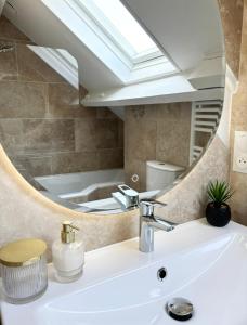 a bathroom with a sink and a mirror at Sara Home in Chennevières-sur-Marne