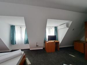 a room with a desk with a computer and two windows at Hotel Pescarus Port Bicaz in Bicaz