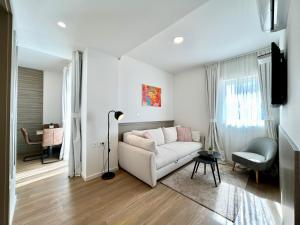 a living room with a white couch and a chair at Deluxe Villa No.10 - Rooms & Apartments in Mandre