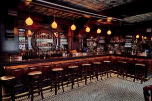 a bar with a lot of bar stools at Hotel Edison Times Square in New York