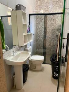 La salle de bains est pourvue de toilettes, d'un lavabo et d'une douche. dans l'établissement Casa para o Rondônia Rural Show, à Ji-Paraná