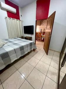 - une chambre avec un lit et une télévision à écran plat dans l'établissement Casa para o Rondônia Rural Show, à Ji-Paraná