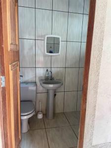 La petite salle de bains est pourvue de toilettes et d'un lavabo. dans l'établissement Casa para o Rondônia Rural Show, à Ji-Paraná