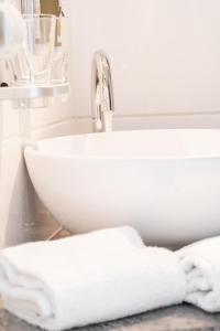 a bathroom sink with white towels on a counter at Manufaktur Boutique Hotel in Stadt Wehlen