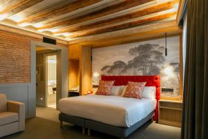 a bedroom with a large bed with a red headboard at Hotel Boutique La Pau in Barcelona