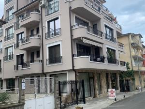 a white building with balconies on a street at Sea View Rooms Briz in Nesebar