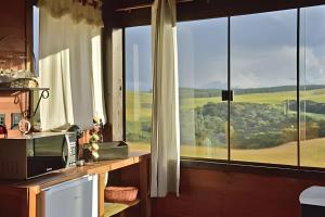 a kitchen with a large window with a view at Chalé Vista do Vale in Cambara do Sul