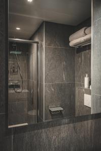 a bathroom with a shower with a glass door at GREEN PARK HOTEL PARIS in Paris
