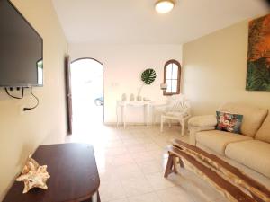 uma sala de estar com um sofá e uma mesa em Immaculate 1-Bed Apartment in Cofresi em Las Flores
