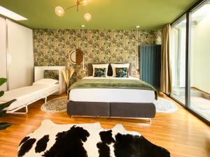 ライプツィヒにあるExklusives Leipzig City Apartment Natureのベッドルーム(ベッド1台、ソファ付)