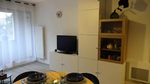 a living room with a table and a tv at Résidence Le Palos - Appartement coquet 4 personnes Résidence LE PALOS MAE-1464 in Cadeilhan-Trachère