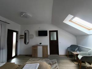 a living room with a skylight and a couch and a table at Casa de Vacanță Zabpatak Vendégház in Rimetea