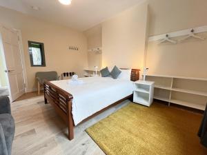 1 dormitorio con 1 cama blanca grande y 1 sofá en West End Gem 3BR Detached Family House en Glasgow
