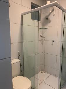 a bathroom with a toilet and a glass shower at Pousada Maanaim in Campina Grande