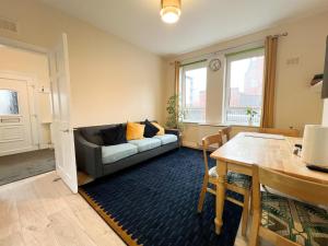 een woonkamer met een bank en een tafel bij West End Gem 3BR Detached Family House in Glasgow