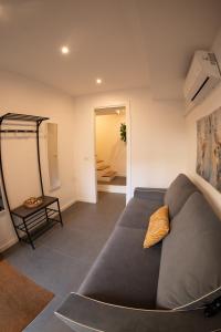 sala de estar con sofá gris y almohada amarilla en Bubi House Porta Romana en Milán