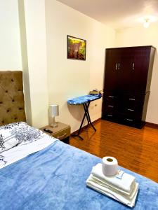 a bedroom with a bed with a dresser and a table at 200. Hermoso Departamento con Servicios Incluidos en Chorrillos in Lima