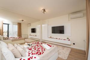 a living room with red roses on a white couch at Sinfonia Lux 1205 in Sajmište