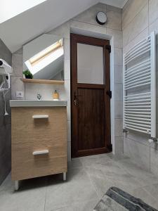 a bathroom with a sink and a wooden door at Casa de Vacanță Zabpatak Vendégház in Rimetea