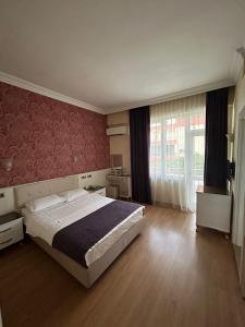 a bedroom with a large bed and a large window at Perlo Hotel City in Antalya