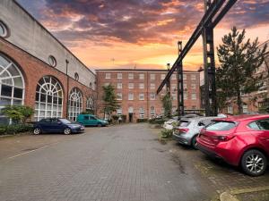 um parque de estacionamento com carros estacionados em frente a um edifício em Duplex Apartment in Glasgow em Glasgow