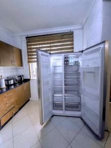a white refrigerator in a kitchen with its door open at Olive Escapes in Dar es Salaam